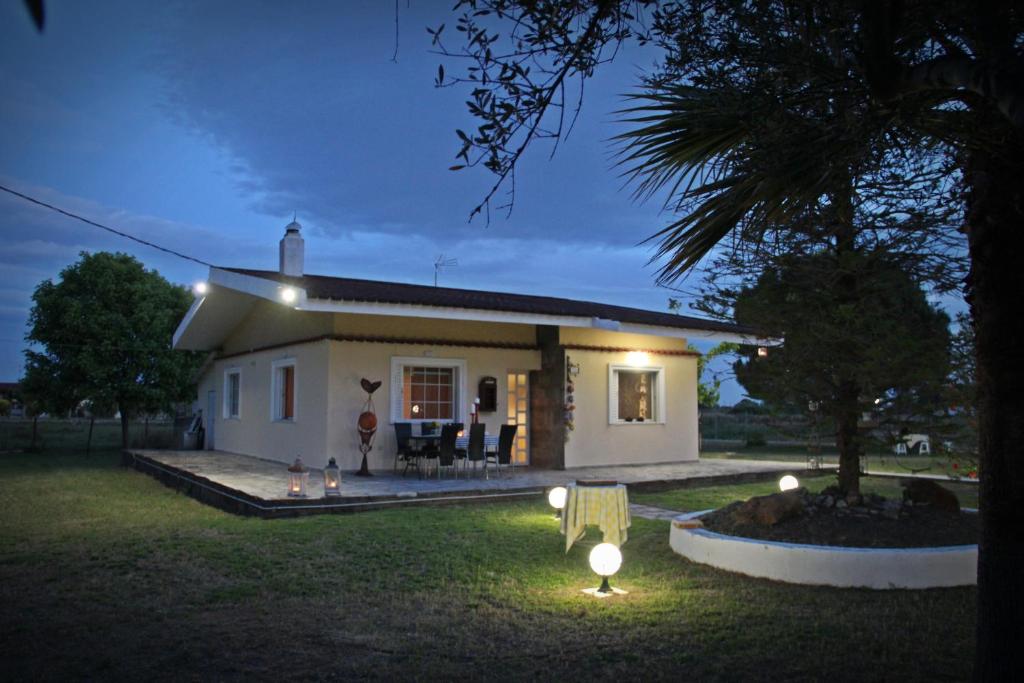 una pequeña casa blanca con luces en el patio en Villa Anastasia! in STROFYLIA pine FOREST!!!, en Kamenitsotaíika