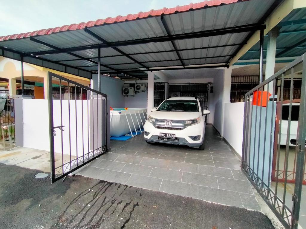a car parked under a garage with a car parked inside at Kak Zai Homestay Port Dickson With Private Pool in Port Dickson