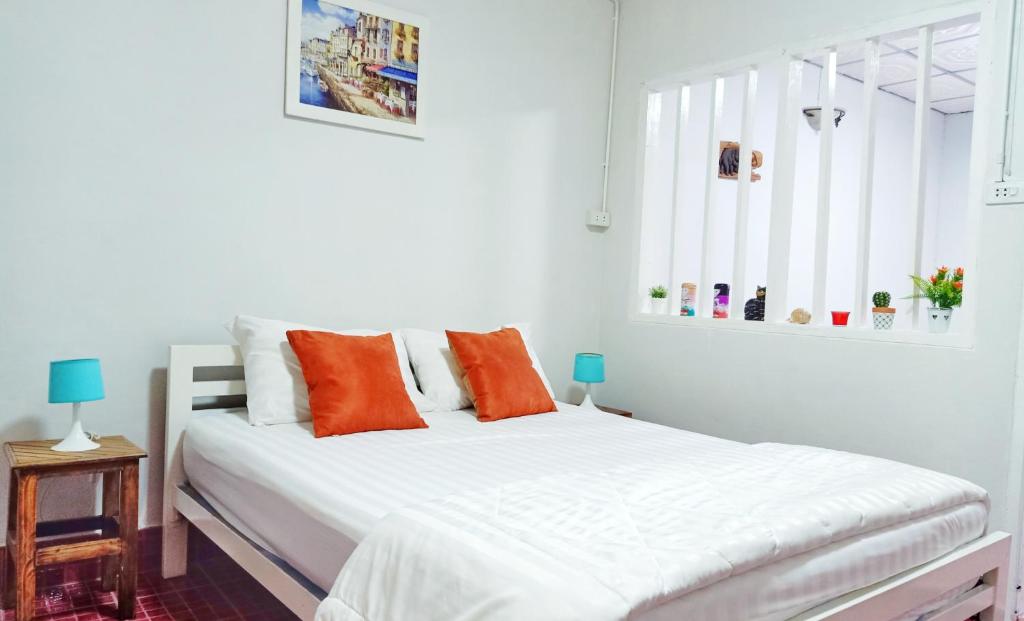 a bedroom with a white bed with orange pillows at The whole house not share for 5 guests in Hat Yai