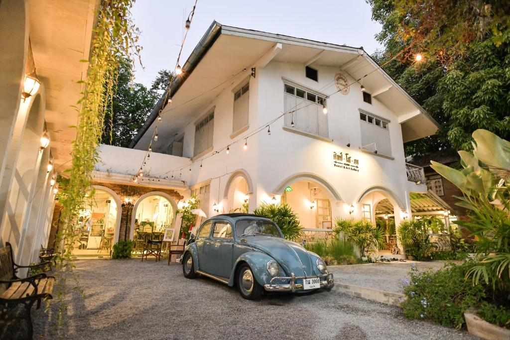 un viejo coche azul estacionado frente a una casa en Silsopa Hostel en Nong Khai