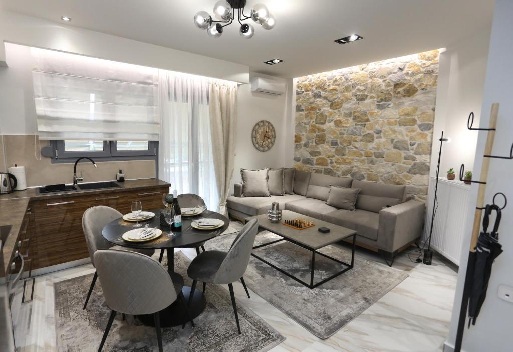 LA Larissa Luxury Apartments Trekke في لاريسا: غرفة معيشة مع أريكة وطاولة