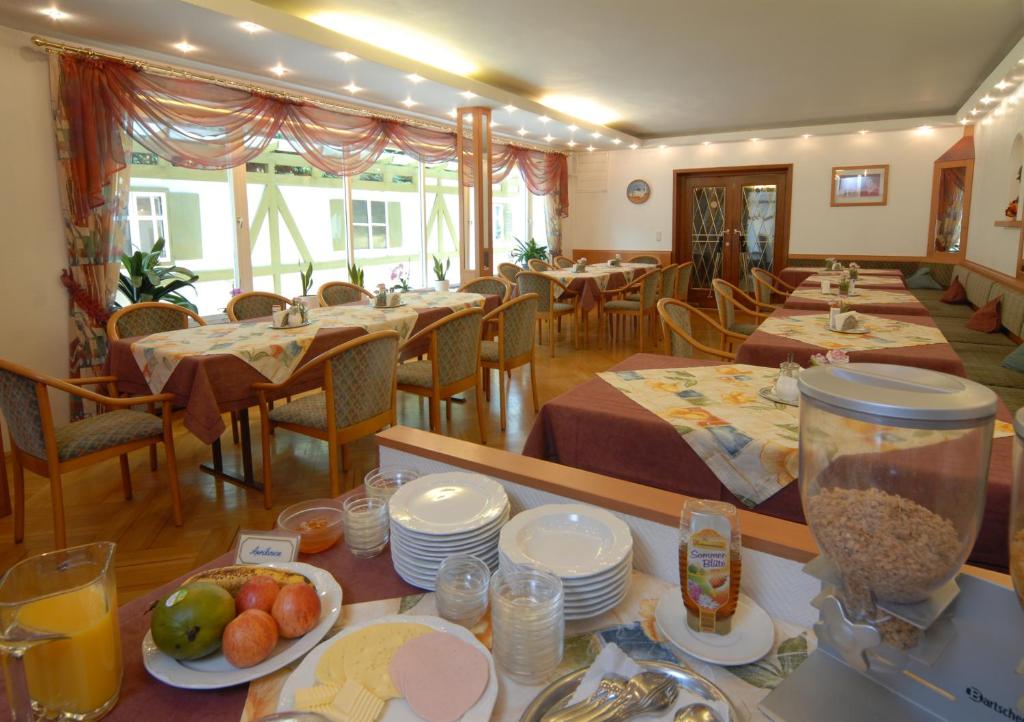 a restaurant with tables and chairs with food on them at Haus am Bach in Bad Wörishofen
