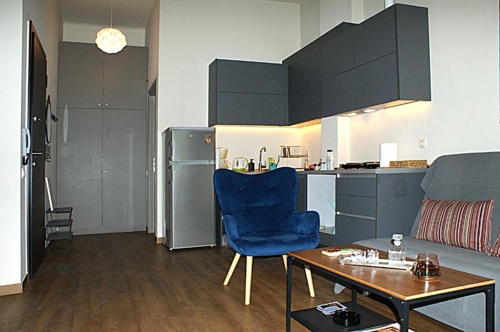 salon z niebieskim krzesłem i stołem w obiekcie Central studio in Monastiraki w Atenach
