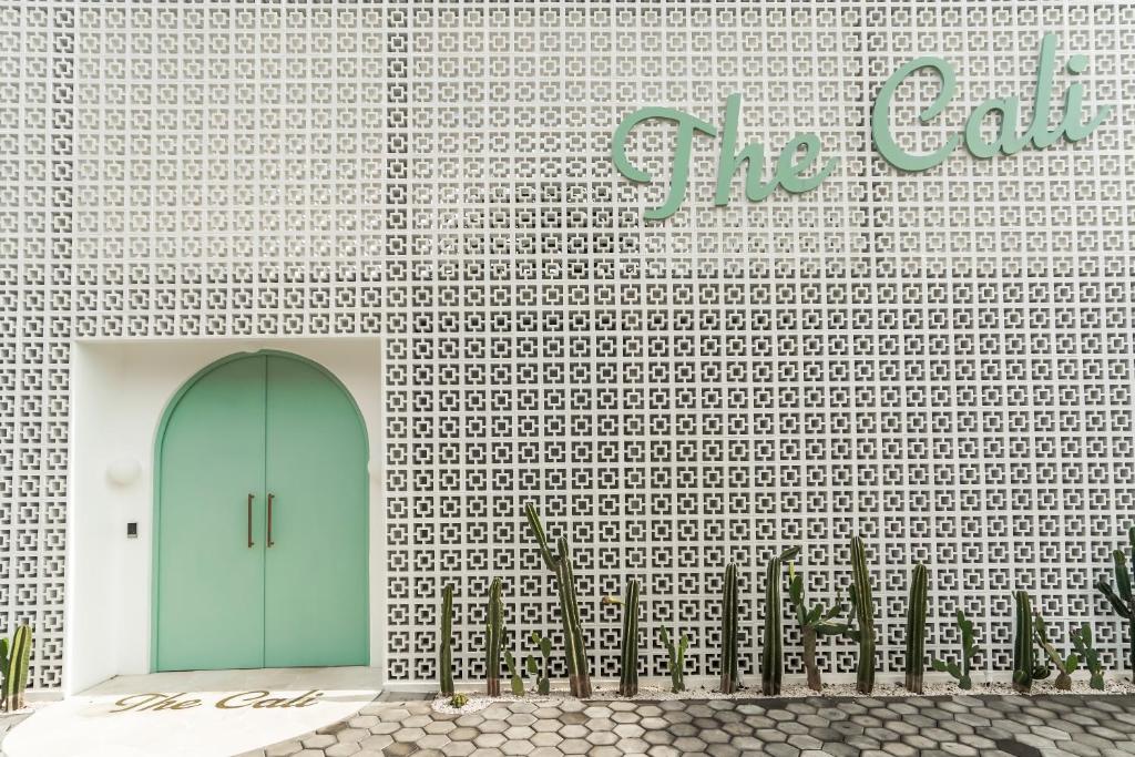 una pared con una puerta verde en un edificio en The Cali Villas Canggu en Canggu