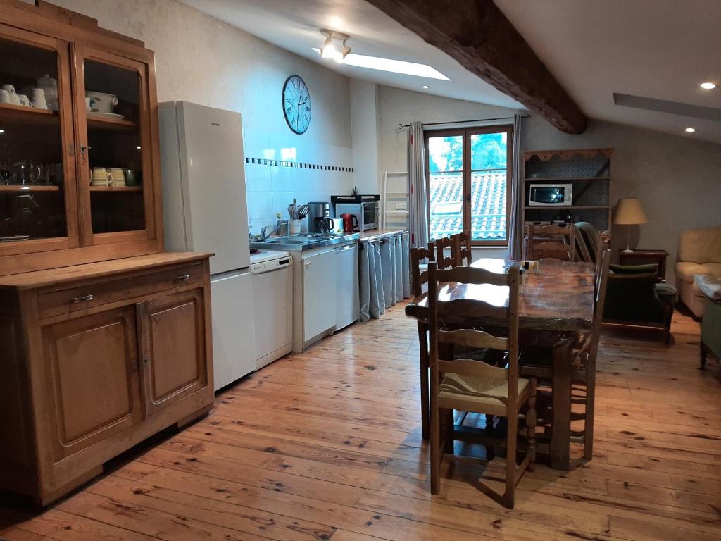 een keuken met een houten tafel en een eetkamer bij Gite le grenier des maraichers in Albigny-sur-Saone