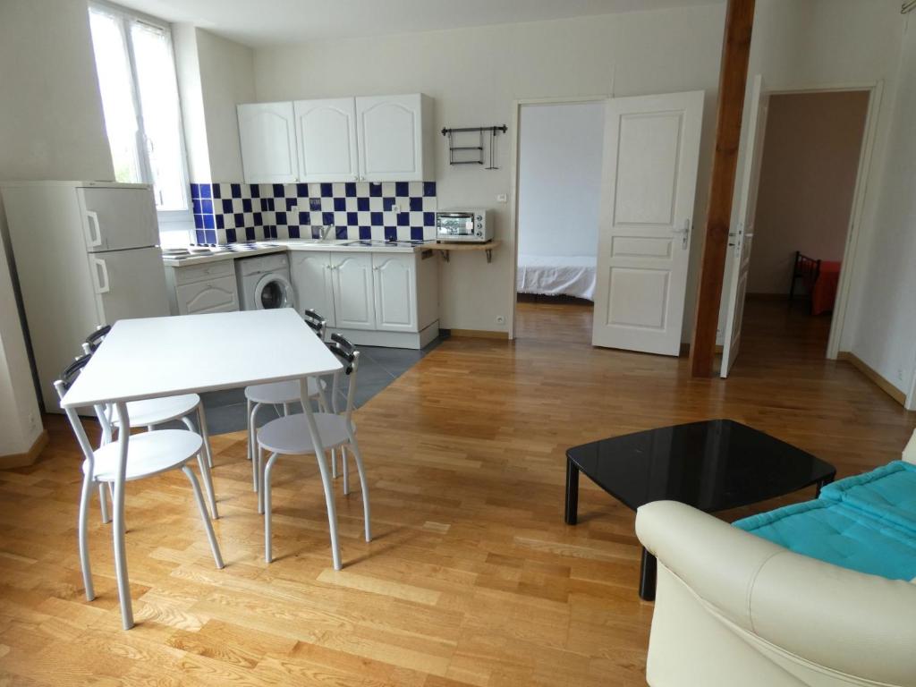 eine Küche und ein Wohnzimmer mit Tisch und Stühlen in der Unterkunft Appartement Charmant, quartier calme in Nancy