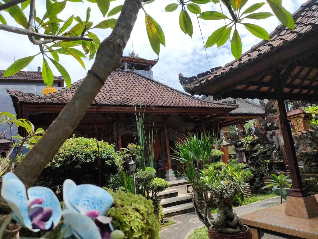 a garden with butterflies in front of a building at Dika Accommodation Ubud in Ubud