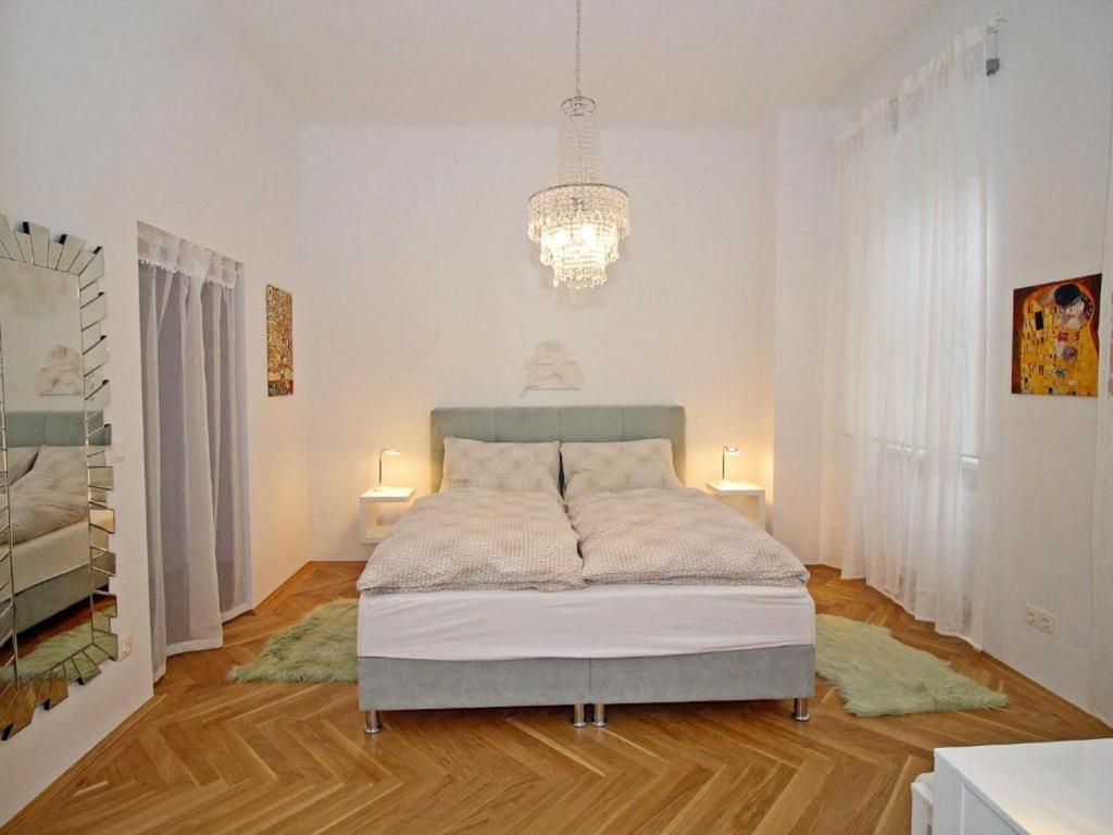 a bedroom with a bed in a room with a chandelier at Ferienwohnung Klimt in Vienna