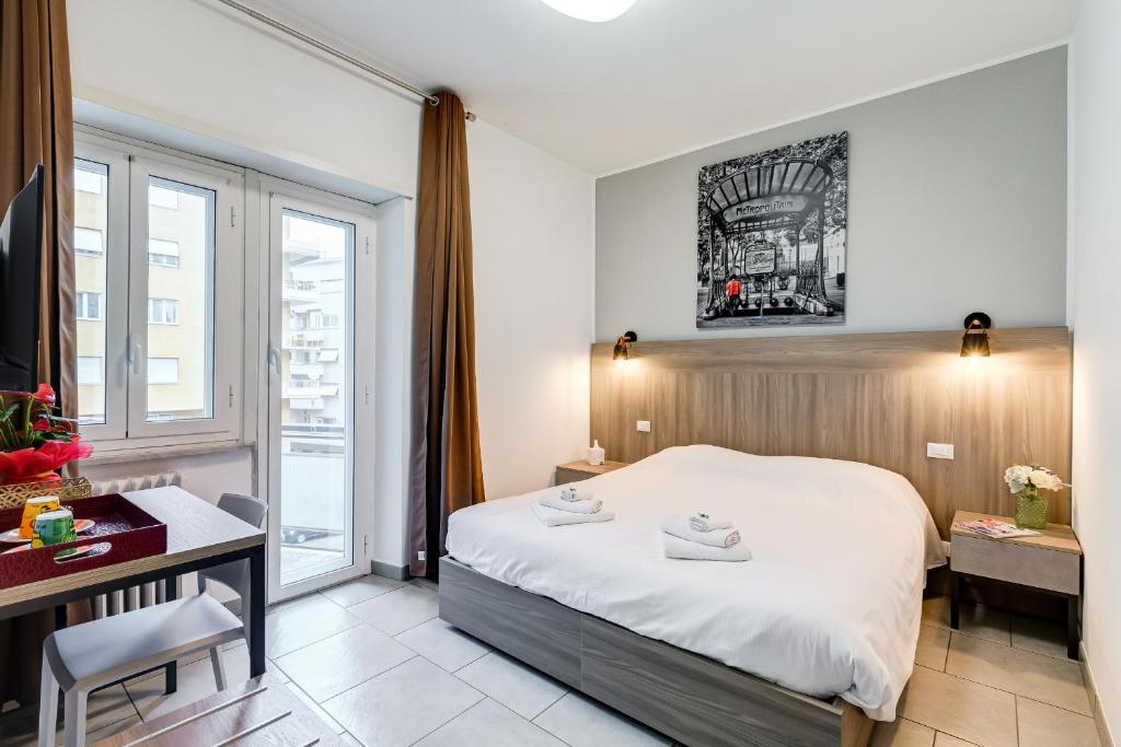 ローマにあるB&B Casa Der Poetaのベッドとデスクが備わるホテルルームです。
