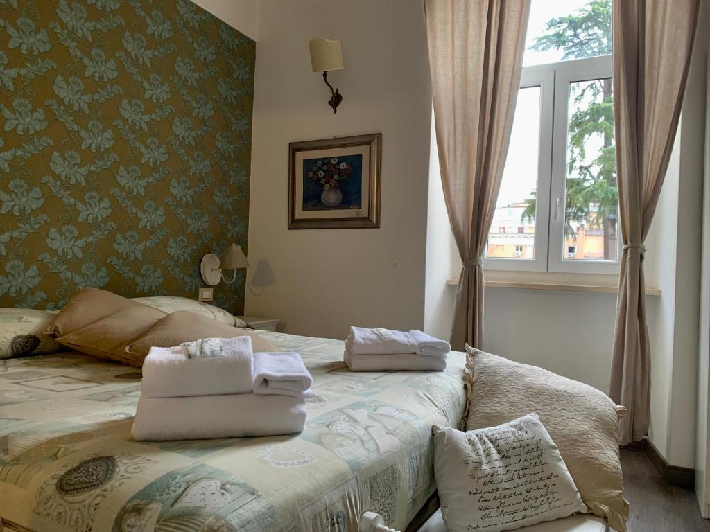 a bedroom with a bed with towels on it at Guest House Casa Vicenza in Rome