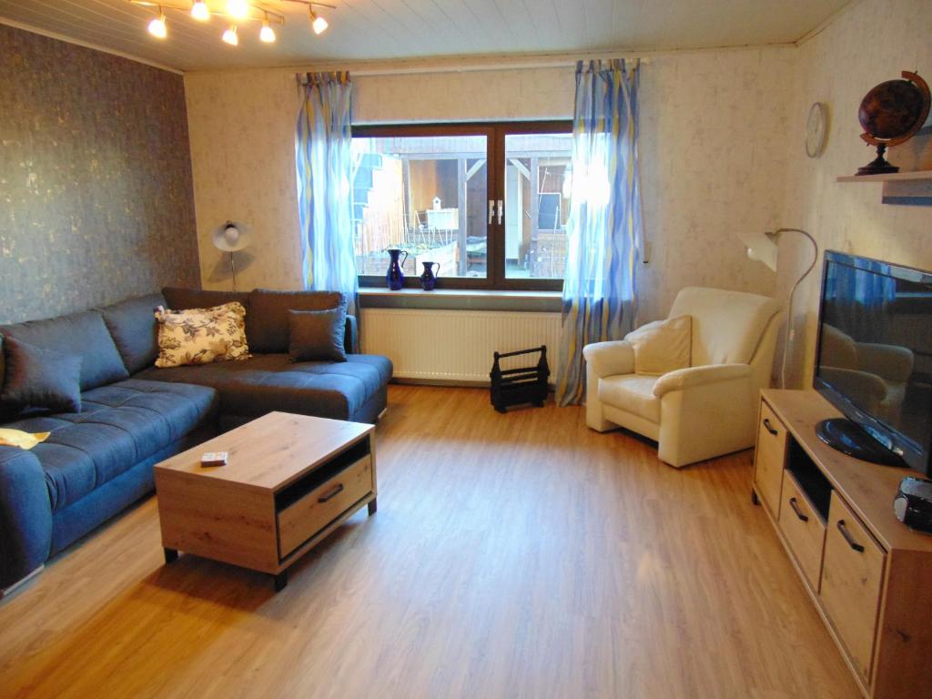 a living room with a blue couch and a chair at Ferienwohnung Astor zwischen Rhein und Mosel in Plaidt