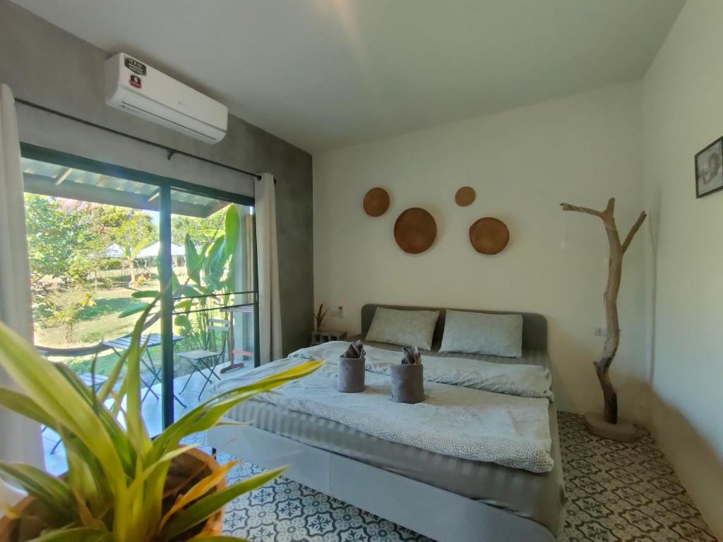 1 dormitorio con cama y ventana grande en DOX Ko Lanta en Ko Lanta