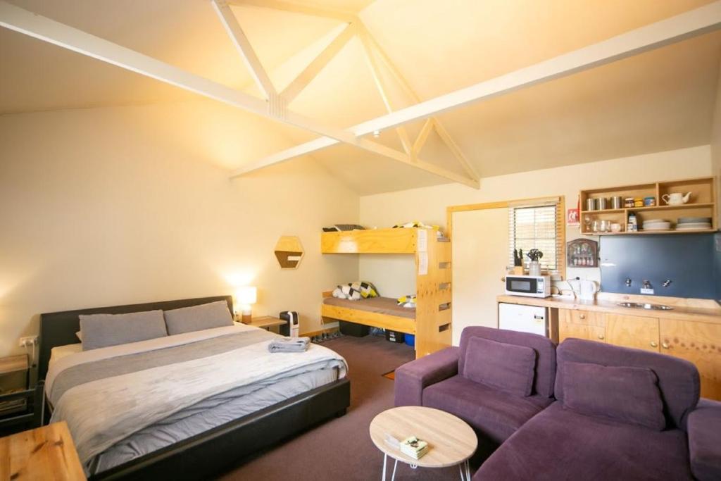 a bedroom with a bed and two purple chairs at 3 Hills at The Good Place in Staverton