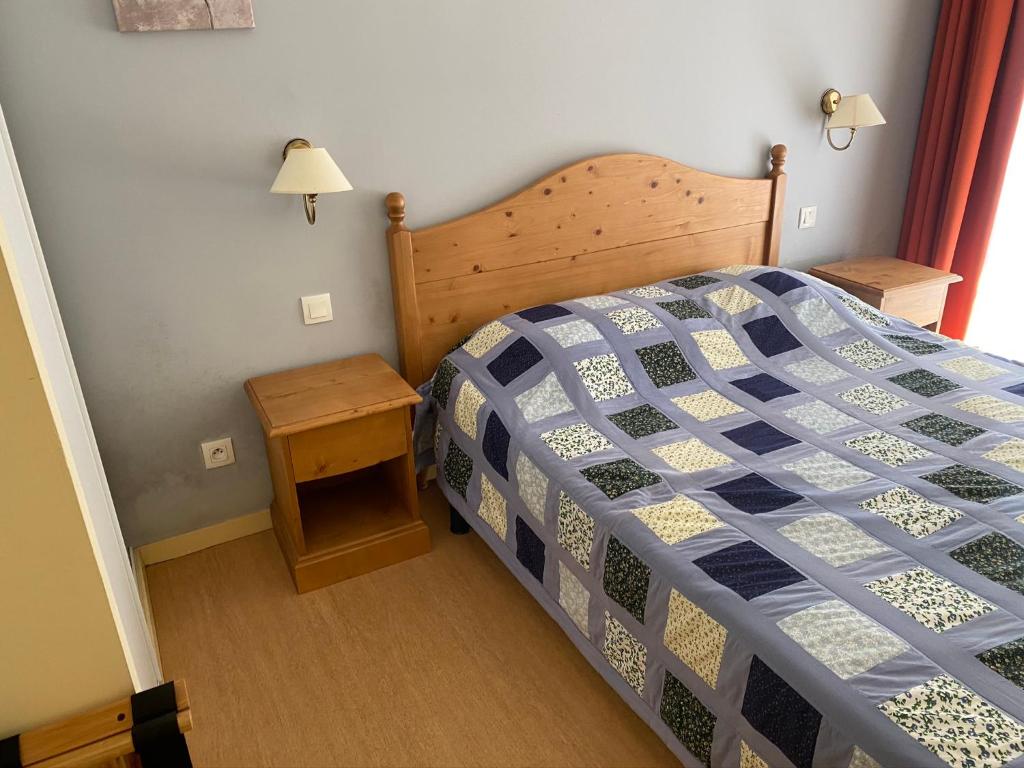 sypialnia z łóżkiem z niebiesko-białą kołdrą w obiekcie T2 + Tout Confort + Terrasse w mieście Aulus-les-Bains