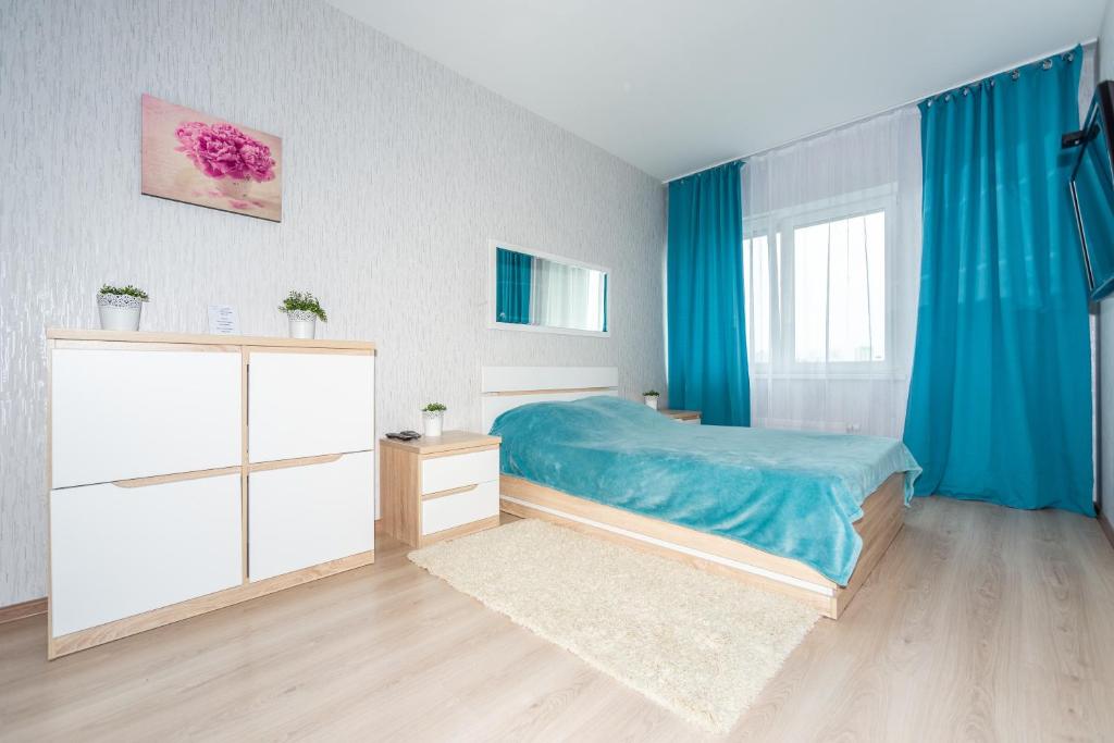 a bedroom with a bed and blue curtains at Гостиница Пермь Апарт-Отель SC in Perm