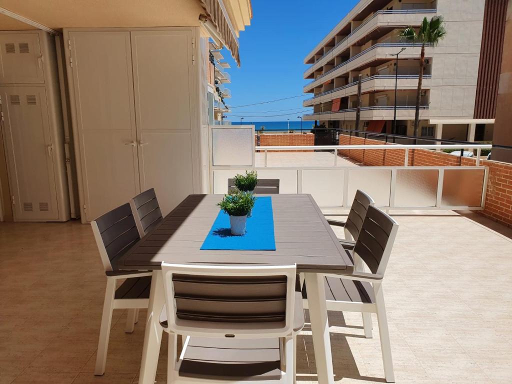 un tavolo da pranzo e sedie sul balcone di APARTAMENTO CON GRAN TERRAZA, PISCINA Y CON VISTAS AL MAR, A SOLO 50 m DE LA PLAYA a Daimuz