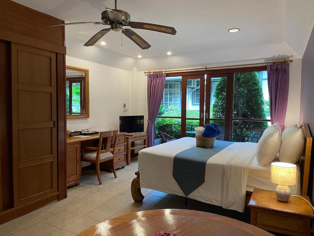 una camera da letto con un letto, una scrivania e un tavolo di The Pavillon by The Pace Phuket Boutique Resort a Rawai Beach