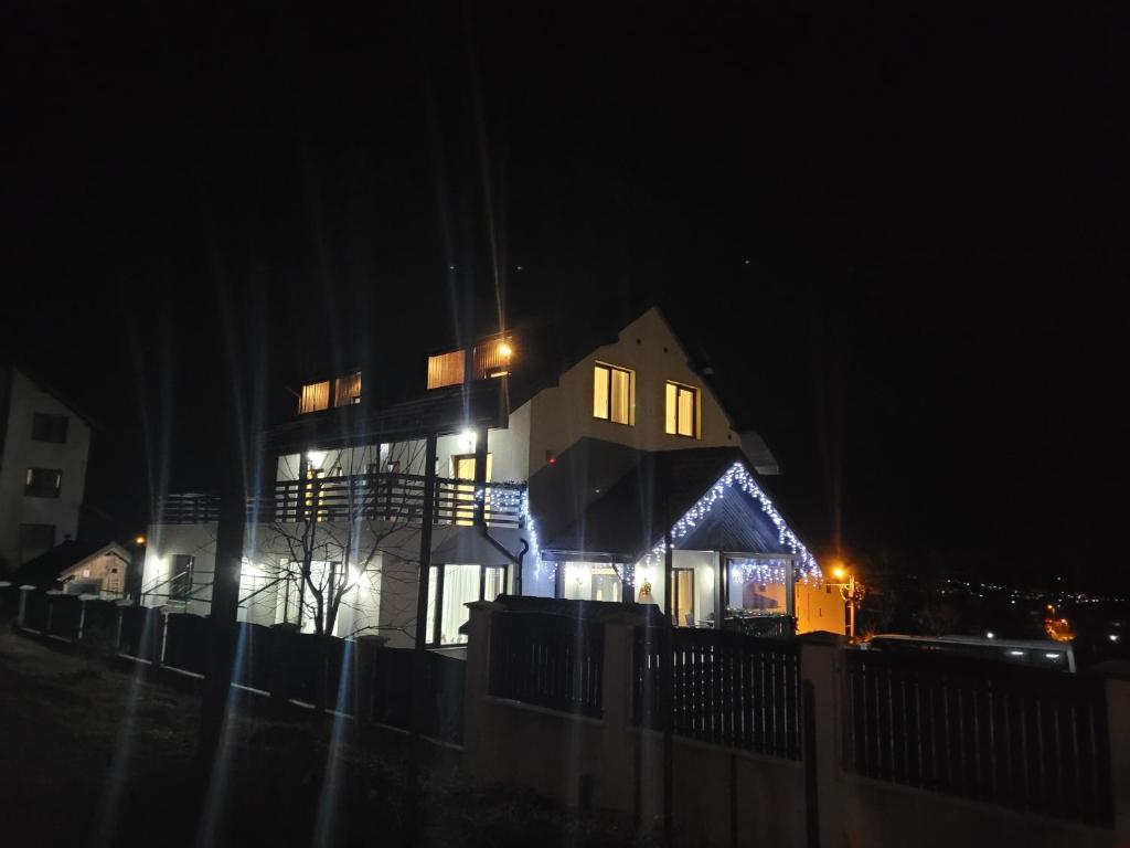 a house lit up at night with lights on it at Casa Aryana, adults only in Bran