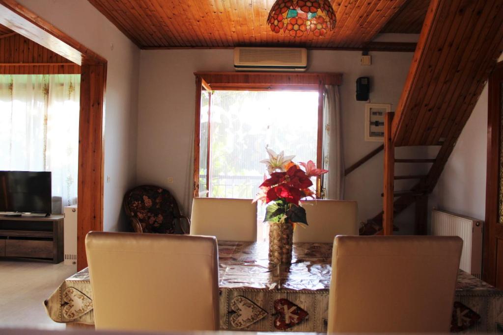 une table à manger avec des chaises et un vase de fleurs dans l'établissement Komninos' Traditional House, à Artemi