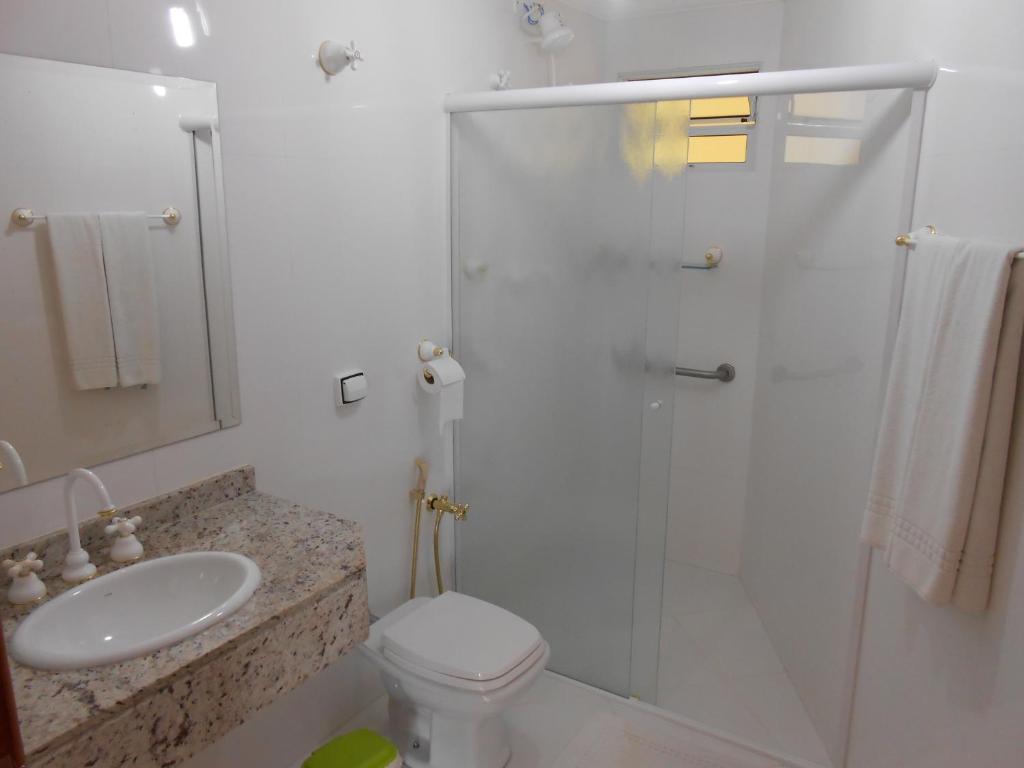 uma casa de banho com um chuveiro, um WC e um lavatório. em Hotel Canto da Riviera em Riviera de São Lourenço