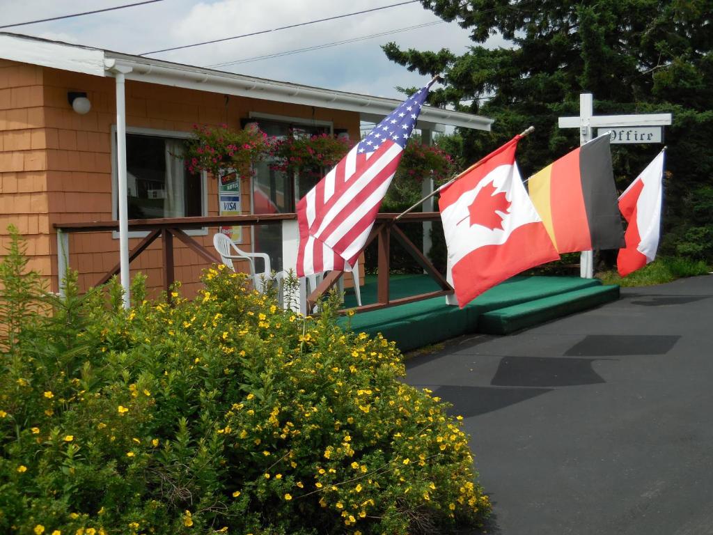 three flags flying in front of a building at Acadia Gateway Motel in Trenton