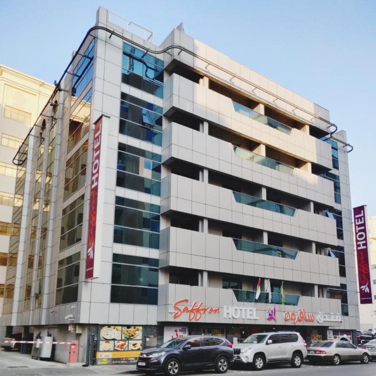 a building with cars parked in front of it at Saffron Hotel in Dubai