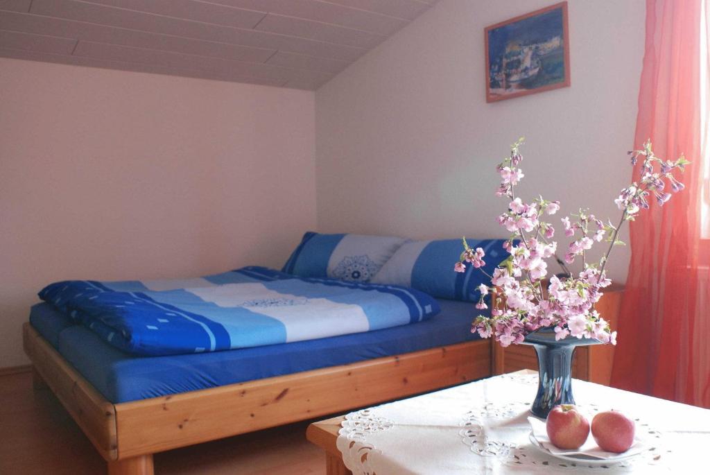 ein Schlafzimmer mit einem Bett und einem Tisch mit Blumen in der Unterkunft Ferienwohnung Pferdezentrum Edersee in Waldeck