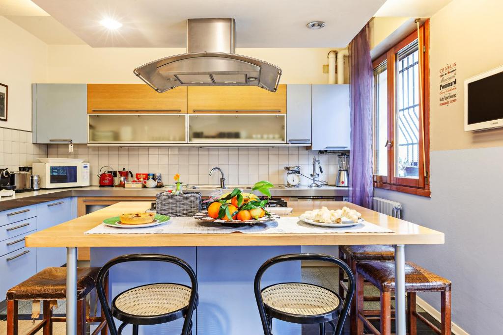 a kitchen with a table with a bowl of fruit on it at A Room for You in Ferrara