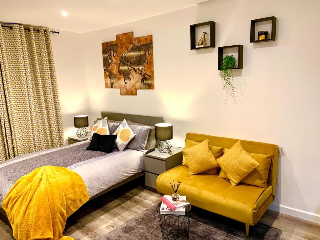 sypialnia z łóżkiem i żółtą kanapą w obiekcie Beautiful Studio apartment in a house with parking w mieście Erith