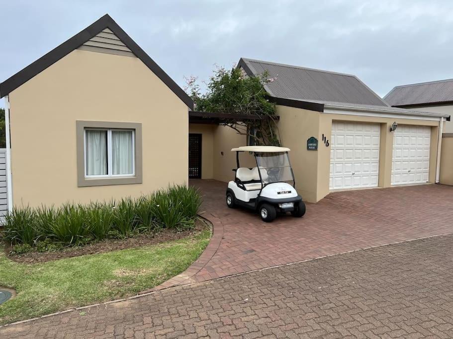 a golf cart parked in front of a house at Ashford House in KwaDukuza