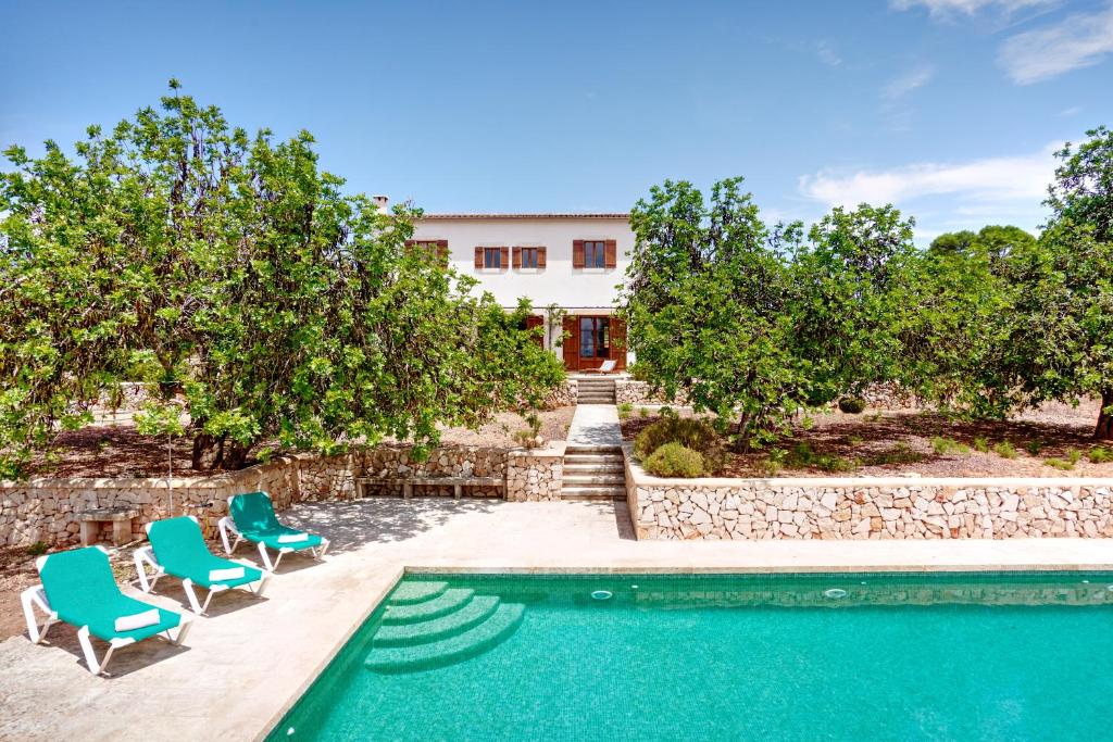 a villa with a swimming pool and two chairs at Finca la Querida, Idylle auf dem Land in Campos