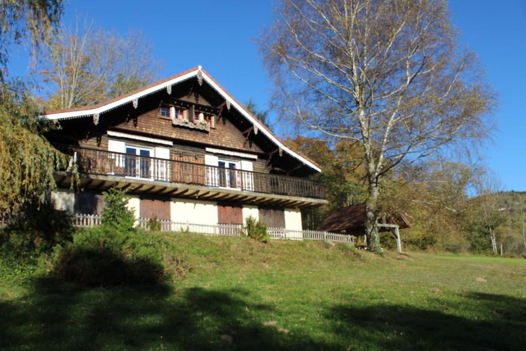a large wooden house with a balcony on a hill at appartement mitoyen dans chalet in Fraize
