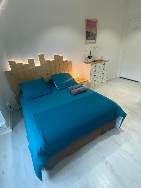 a bedroom with a blue bed with a wooden headboard at Studio Confort Lorient Rue Vauban Hypercentre in Lorient