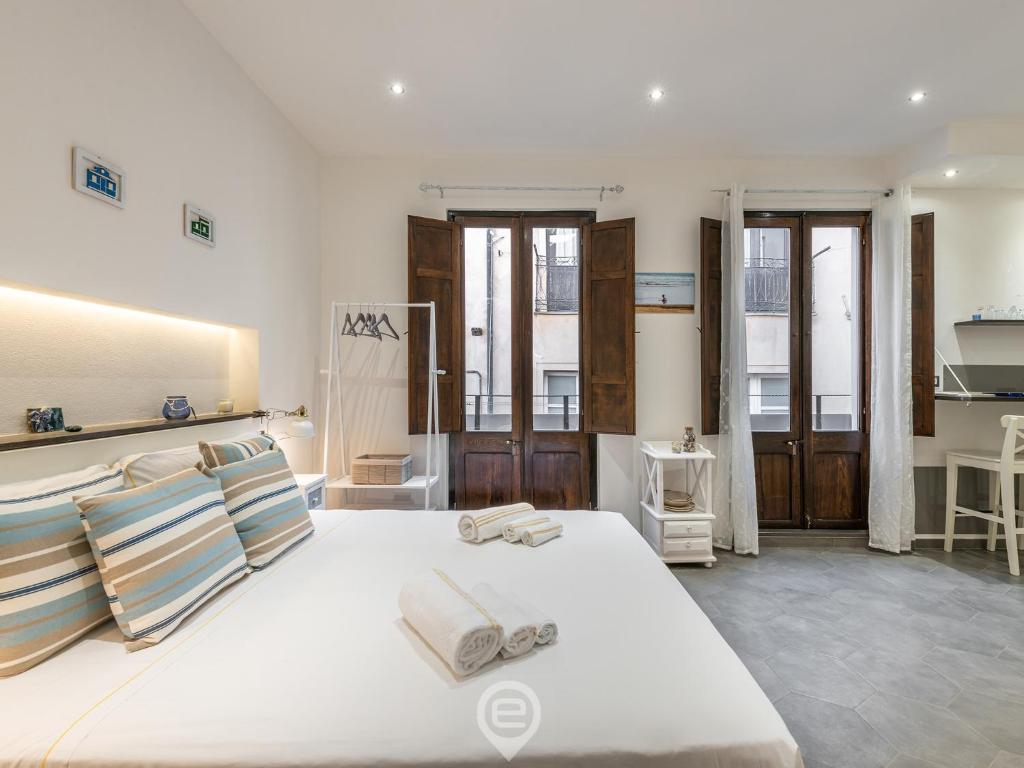 a bedroom with a large white bed with pillows at Studio 73 in Cagliari