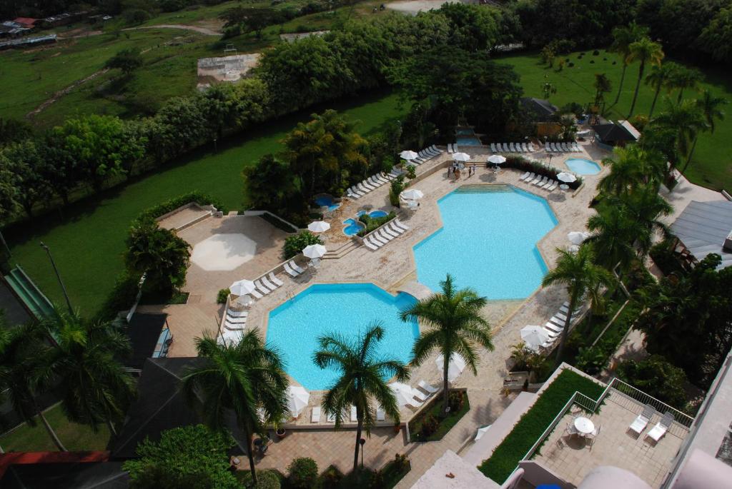 an overhead view of a pool with chairs and umbrellas at Hotel Estelar Altamira in Ibagué