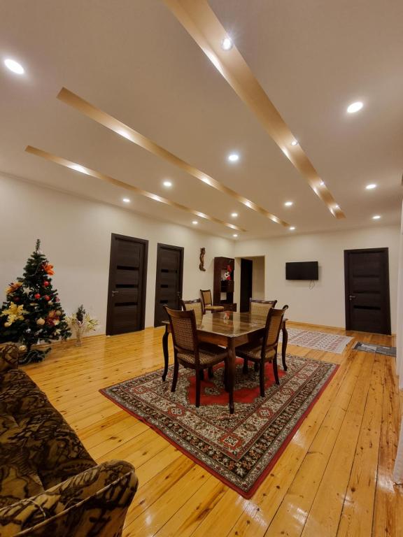 a dining room with a table and a christmas tree at Shorena & Nino in Stepantsminda