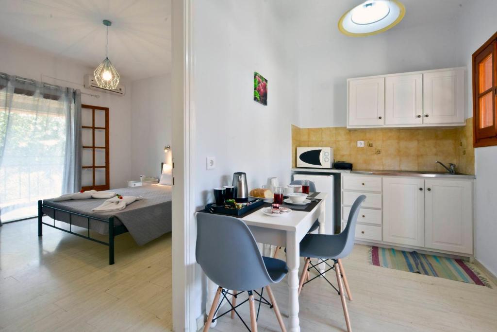 Kalliopi Apartments في رودا: مطبخ وغرفة طعام مع طاولة وكراسي