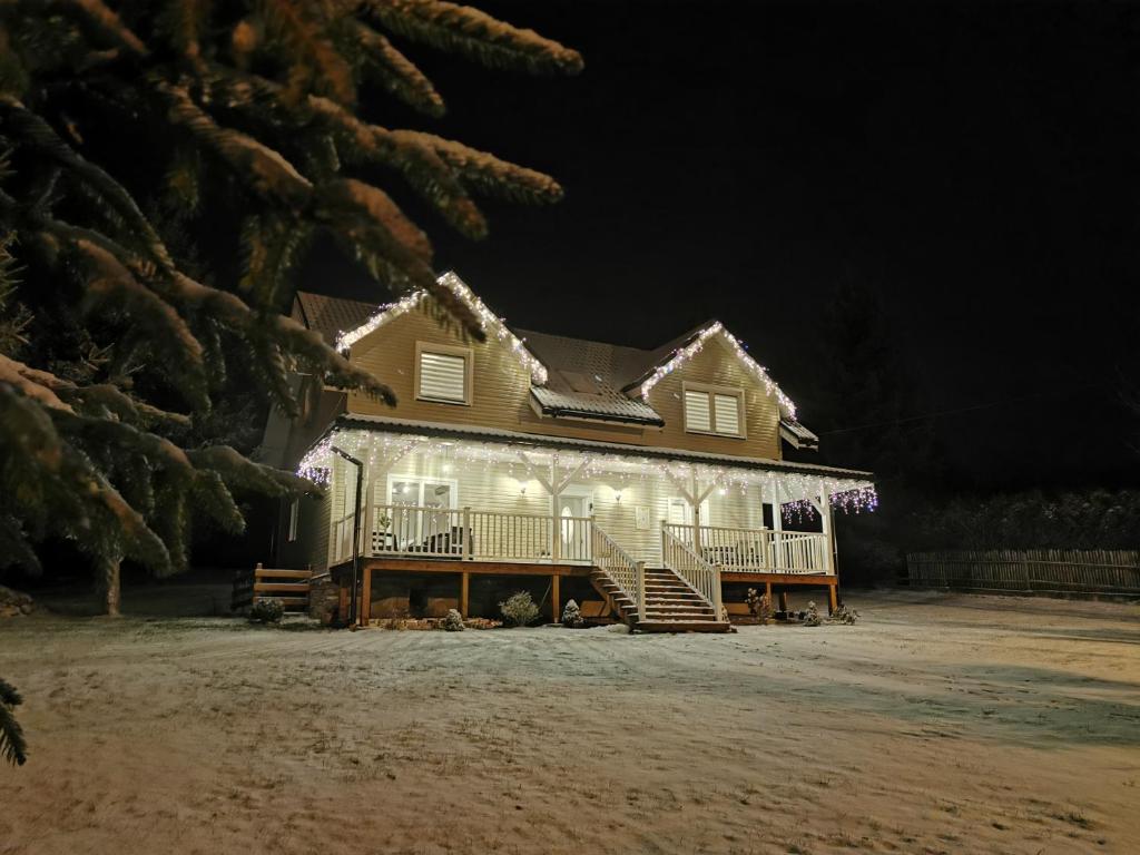 a house lit up at night with christmas lights at Bogdanówka in Skalnik