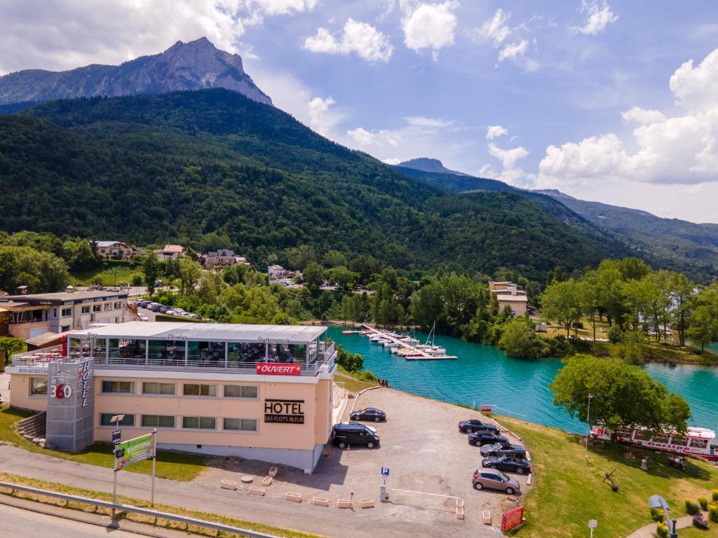 eine Stadt auf einem Fluss mit einem Berg im Hintergrund in der Unterkunft Hôtel Les Flots Bleus in Savines