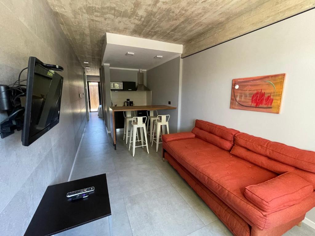 sala de estar con sofá rojo y mesa en dos569 en Mar del Plata