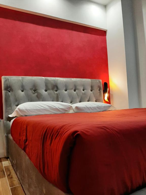 uma cama com uma cabeceira vermelha e uma parede vermelha em Appartamento ALECATIA 2 em Roma