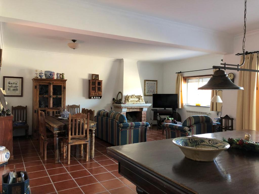 uma sala de estar com mesa e cadeiras em Quinta das Oliveiras em Moimenta da Serra