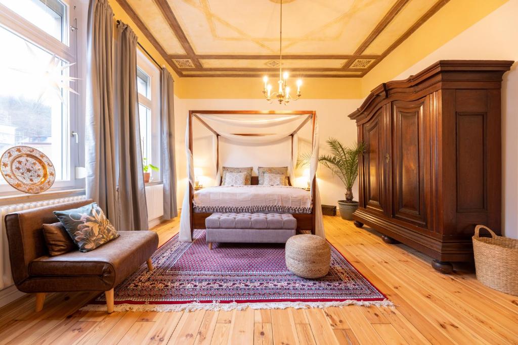 科堡的住宿－Zentral in Coburg: Exklusive Stadtwohnung – ideal für Gruppen，一间卧室配有一张床、一张沙发和一把椅子