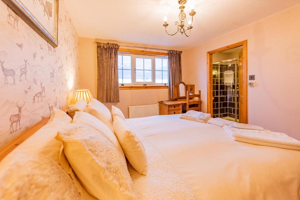 a bedroom with a large white bed with pillows at Benview Bed and Breakfast & Luxury Lodge, Isle of North Uist in Paible