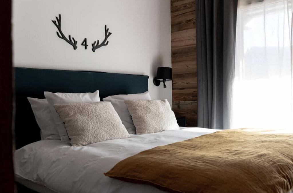 una camera da letto con letto con testiera e cuscini blu di Chalets Alaska a Les Gets
