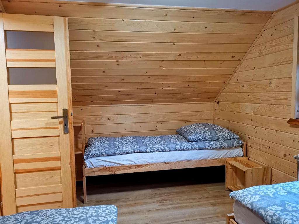 a room with two beds in a wooden cabin at Domki u Basi in Kluszkowce