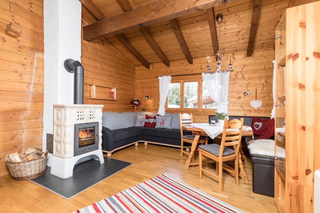 Cabaña de madera con sala de estar con chimenea en Alpen-Chalets Achensee en Maurach