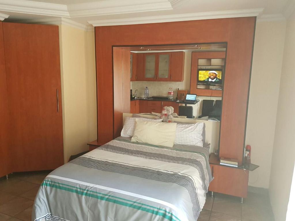 a bedroom with a bed and a kitchen in it at Genie's Nest 2 in Pretoria