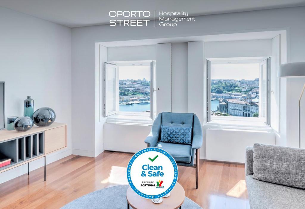 een schone en veilige woonkamer met een blauwe stoel bij Oporto Street das Aldas - River View in Porto