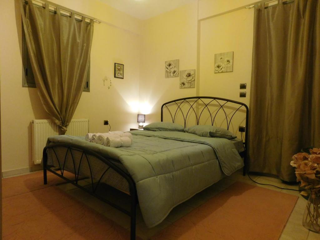 a bedroom with a bed with a green comforter at HOME SWEET HOME in Ioannina